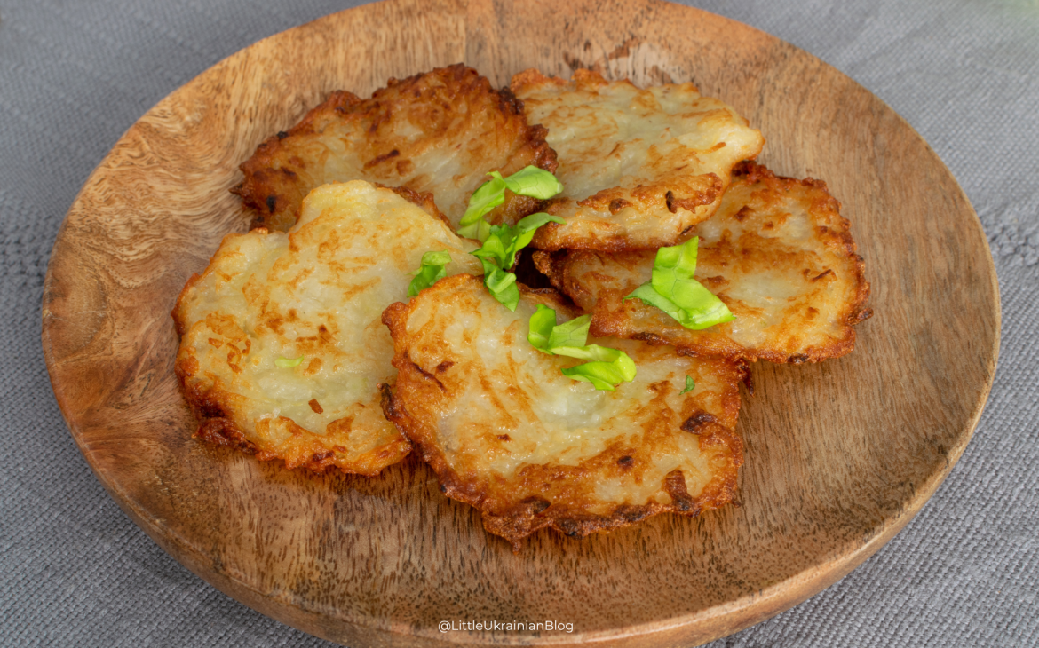 Traditional Ukrainian deruny potato pancakes served with sour cream, a rustic comfort food dish popular across northern Ukraine and the Chernihiv region.