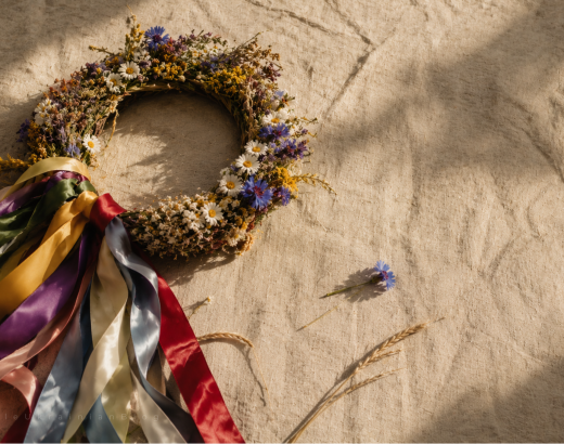 Traditional Ukrainian vinok (flower crown) with colourful ribbons, chamomile, cornflowers, viburnum and wheat, photographed on linen fabric. The vinok is an iconic symbol of Ukrainian culture, folklore, heritage, flower symbolism and traditional customs.