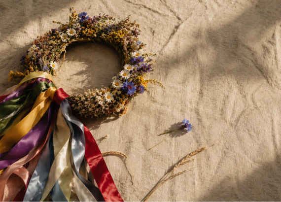Traditional Ukrainian vinok (flower crown) with colourful ribbons, chamomile, cornflowers, viburnum and wheat, photographed on linen fabric. The vinok is an iconic symbol of Ukrainian culture, folklore, heritage, flower symbolism and traditional customs.